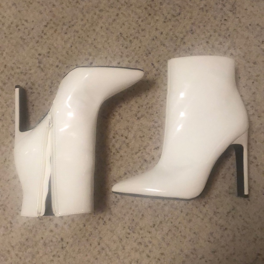 White, pointed toe heeled booties.